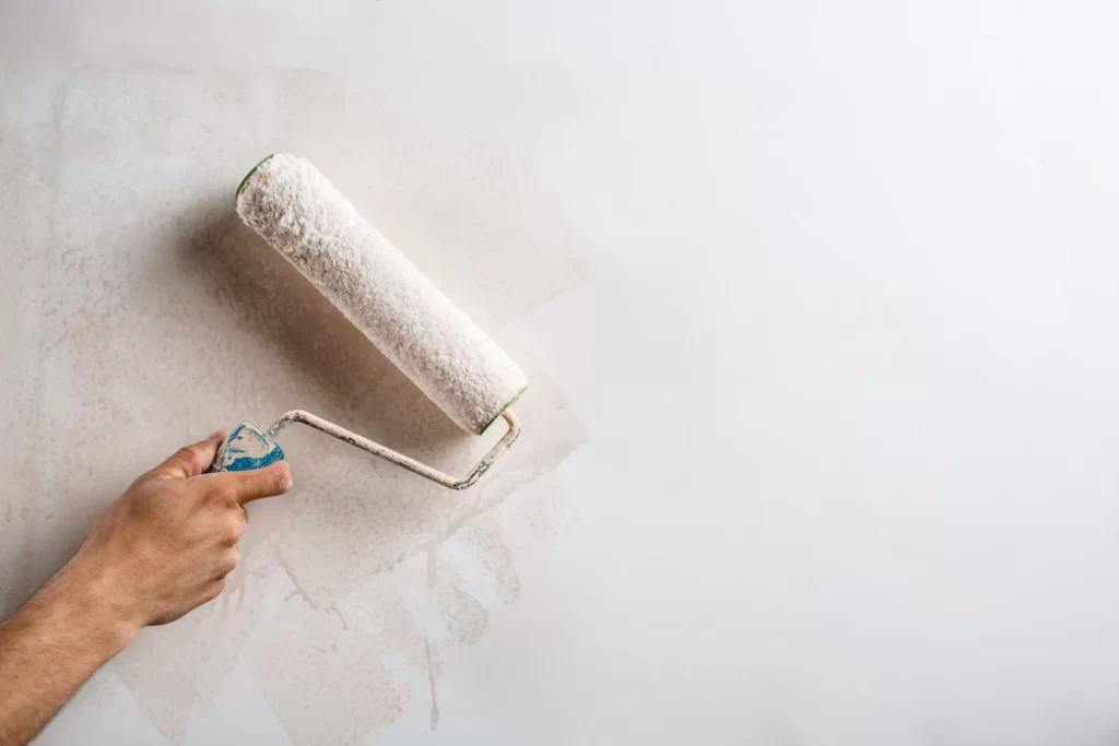 close-up-hand-painting-wall-with-roller_176420-4760