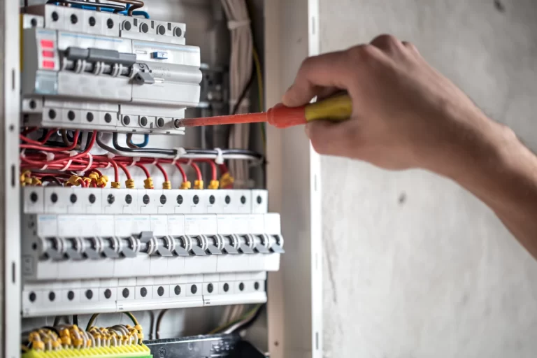 man-electrical-technician-working-switchboard-with-fuses-installation-connection-electrical-equipment-close-up_169016-5077
