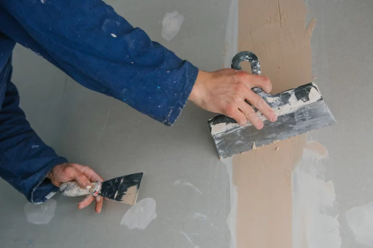 plasterer-man-works-plastering-two-trowels-plasterboard-blue-uniform_8353-5731